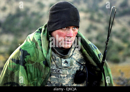 U.S. Army Sgt. Nathan Schrock tries to keep warm after waking up on a cold morning in the mountains near Sar Howza in Paktika province, Afghanistan, Sept. 4, 2009. Schrock is assigned to the 1st Squadron, 40th Cavalry Regiment.  Staff Sgt. Andrew Smith Stock Photo
