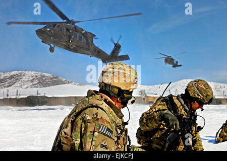 U.S. Army Col. Mark H. Landes Left and 1st Lt. Josh Kopsie assigned to 3rd Brigade Combat Team, 1st Armored Division  kneel on the landing zone while two UH-60 Black Hawks begin to land on Command Outpost Nerkh, Wardak province, Afghanistan, Feb. 15, 2012. Stock Photo