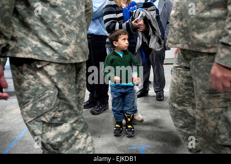 A young boy watches Soldiers of the 86th Infantry Brigade Combat Team leave after their departure ceremony in Burlington, Vt., Jan. 8, 2010. The unit has been ordered to Afghanistan in the largest deployment of Vermont National Guard troops since World War II.  U.S. Navy Petty Officer 1st Class Chad J. McNeeley Stock Photo