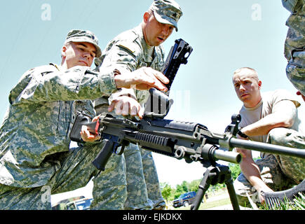 Sgt. Nathan Snyder of Commercial Point, Ohio, instructs Spc. Christopher Irwin left of Gahanna, Ohio, and Spc. John Markley right of Akron, Ohio, on the operation of the M249 machine gun at Camp Perry, Ohio, June 3, 2013. These Headquarters, 37th Infantry Brigade Combat Team, Soldiers are conducting their first Annual Training since their deployment to Afghanistan. Army photo by Staff Sgt. Sean Mathis Stock Photo