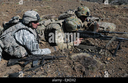 SSG Christopher Camaioni, an infantryman from the 1st Battalion, 14th Infantry Regiment gives guidance to soldiers of the 7th Royal Australian Regiment as they provide suppressive fire on enemy targets during their live fire exercise on June 6. The exercise is part of the Theatre Security Cooperation Program designed to ensure security in the Pacific region by utilizing allied forces in combined operations. Stock Photo