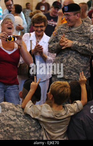 A child gives bunny ears to Governer of the State of Minnesota Tim Pawlenty and a U.S. Army Soldier after a deployment ceremony for Soldiers from the 2nd Battalion, 135th Infantry Unit in Rochester, Minn., July 15, 2007. The Soldiers will leave for Camp Atterbury, Ind., on July 18, 2007, for training for their next mission to Kosovo. Training will include driving military vehicles on the narrow roads of Kosovo and identifying and reacting to land mines.  Sgt. Lynette Hoke Stock Photo