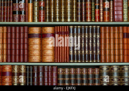 Old library of vintage hard cover books on shelves Stock Photo