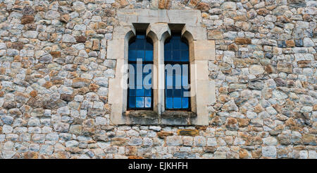 Old stone medieval wall with two windows in center Stock Photo