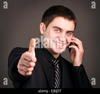 man talking on  phone showing thumb Stock Photo