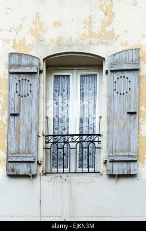 Grey-blue paint peeling off wooden shutters on an old building in Chagny, Burgundy, France. Stock Photo