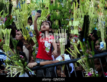 Paranaque City, Philippines. 29th Mar, 2015. A Filipino child records devotees waving palm fronds during mass on Palm Sunday at the Baclaran Church. Palm Sunday marks the triumphant entry of Jesus Christ into Jerusalem, kicking off the Holy Week for Catholics worldwide. © Richard James Mendoza/Pacific Press/Alamy Live News Stock Photo