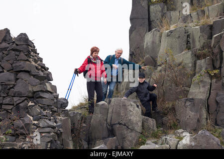 Senior couple and child boy trekking on rocky terrain. Stock Photo