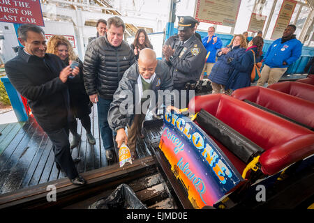 Coney Island, USA. 29th Mar, 2015. Brooklyn Borough President Eric Adams christens the 2015 season of the Luna Park Coney Island Cyclone by breaking a bottle of Egg Cream on the roller coaster. The Cyclone got stuck on its inaugural run of the Summer 2015 season on Sunday, March 29, 2012. The train stopped just short of the initial drop as a safety feature kicked in as the conveyor belt used to propel the coaster slipped off of its track. The first riders had to escorted down the landmark coaster after being stuck for about 5 mins. There were no injuries. Credit:  Richard Levine/Alamy Live New Stock Photo