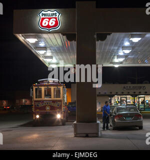 A man pumps gas at night at a Phillips 66 station in Santa Fe, New Mexico. Stock Photo