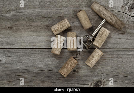 Several used corks and opener on aged cedar wooden boards in vintage style. Top view angled shot in horizontal format with copy Stock Photo