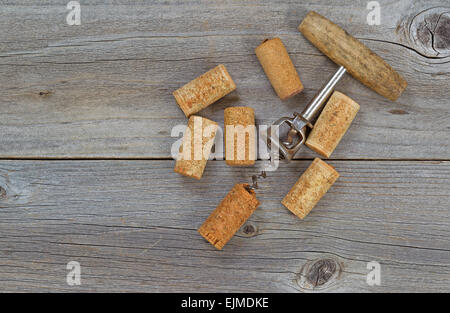 Several used wine corks and opener on rustic wooden boards. Top view angled shot in horizontal format with copy space. Stock Photo