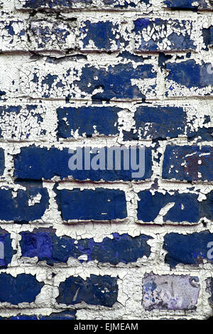 Color shot of an old blue brick wall with peeling paint. Stock Photo
