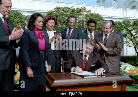 US President Ronald Reagan at the signing ceremony to create a Martin Luther King National Holiday in the Rose Garden of the White House November 2, 1983 in Washington, DC. Joining the President is (L-R): Vice President George Bush, Coretta Scott King, Rep. Katie Hall, Secretary Samuel Pierce and Senator Howard Baker. Stock Photo