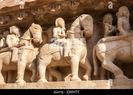 Carvings at a Hindu temple in the Western Group at Khajuraho, Madhya Pradesh, India depicting mounted warriors on horseback Stock Photo