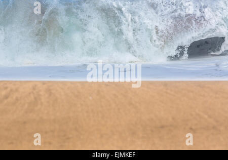 Smooth and sandy beach leading into the distance with detailed focus on the breakers of stormy sea Stock Photo