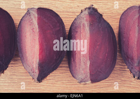 Slices of boiled beet on a wooden background close up. Pastel color filter Stock Photo