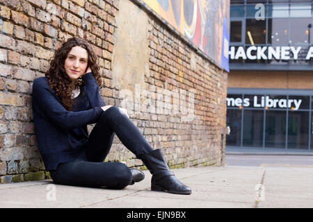 young woman sitting on the pavement relaxing Stock Photo
