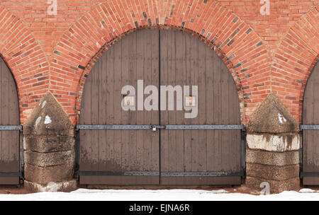 Old locked wooden gate in red brick fortress wall, Hamina, Finland Stock Photo