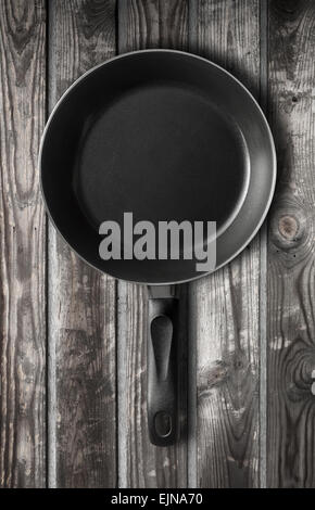Empty black frying pan stands on old dark gray wooden table background Stock Photo