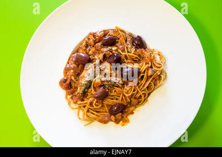 Spaghetti with sardines and olives in white bowl, a Sicilian dish Stock Photo