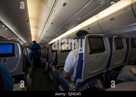 Passengers in flight international flight watch movies Stock Photo