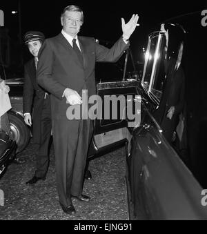 American actor John Wayne leaving the Ambassadeurs Club in Hamilton Place, London watched by doorman Tas Alder. 17th January 1974. Stock Photo