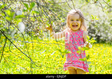 Happy little girl in spring sunny park Stock Photo