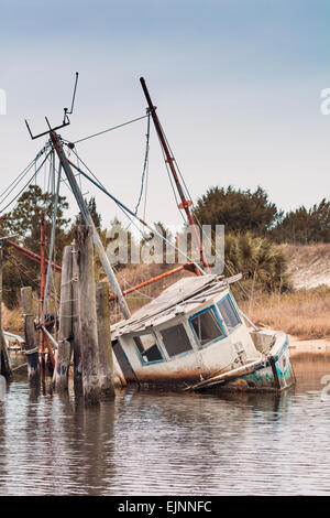 Sunken shrimping boat tied to an old pier in the intercoastal waters of Florida. Stock Photo