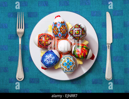easter egg on white plate, knife and fork on table Stock Photo