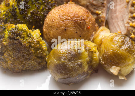 Grilled brussels sprouts with broccoli and mushrooms on white plate. Close up image Stock Photo
