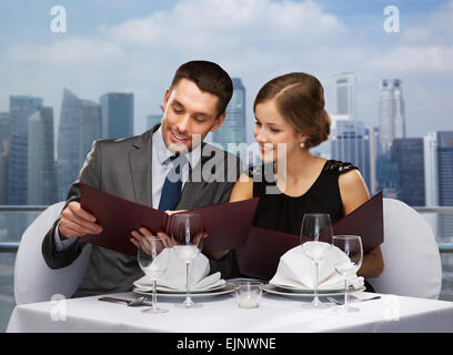 smiling couple with menus at restaurant Stock Photo