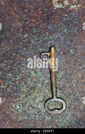 Old key on a rusty metal texture background Stock Photo