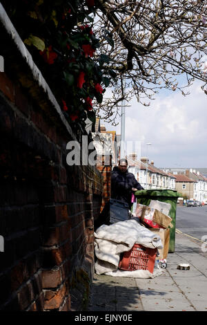 a man putting garbage and rubbish bin out into the road ready for collection by the refuse truck Stock Photo