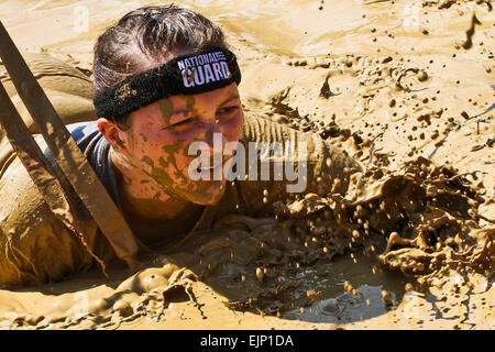 2nd Lt. Mary Kauffman, Ohio Army National Guard, crawls through mud during the Warrior Dash Aug. 11, 2013, in North Lawrence, Ohio. Kauffman and 19 other Ohio Guard Soldiers participated in the event to promote recruiting and retention.  Staff Sgt. Sean Mathis Stock Photo