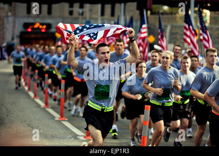 A Soldier sprints to the formation while carrying an American Flag during the New York City Tunnel to Towers Run, Sept. 30. United States Military Academy at West Point cadets and FDNY firefighters lined the final stretch of the run. The run is in support of the Stephen Siller Tunnel to Towers Foundation, which works to build homes for injured troops and provide scholarships to the children of fallen service members and firefighters. Siller was an off-duty New York City firefighter who headed back to the city to help after the attacks on 9/11. When he reached as far as car traffic would allow  Stock Photo