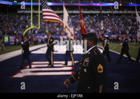 A joint service color guard marches off the field along with Marines, sailors, coast guardsmen and soldiers at the conclusion of a presume ceremony at the New York Giants military appreciation game vs the Dallas Cowboys, here, Nov. 14. Official Marine Corps photo by Sgt. Randall A. Clinton Stock Photo
