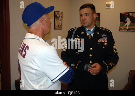 Sgt. 1st Class Leroy A. Petry, 75th Ranger Regiment Medal of Honor recipient, meets with New York Mets manager Terry Collins, prior to their baseball game against the Philadelphia Phillies at Citi Field in New York City, July 16. Petry met with players and coaches, prior to the game and received a standing ovation from the fans during the third inning.  Sgt. 1st Class Michael R. Noggle, USASOC Public Affairs/medalofhonor/petry/ Stock Photo