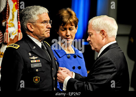 Secretary of Defense Robert M. Gates presents the Defense Distinguished Service Medal to Army Chief of Staff Gen. George W. Casey a during ceremony at the Pentagon, April 11, 2011, marking his retirement from active duty after more than 40 years of dedicated service.  His wife Sheila, who sharred every step of his distinguished career, watches the presentation.  Moments later, Gates presented her the Defense Distinguished Civilian Service Medal in recognition of her tireless work in support of Army families.   R. D. Ward Stock Photo