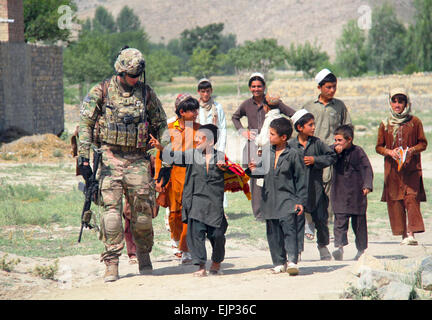 While on patrol, U.S. Army 1st Lt. Brendan D. Murphy of Easy Company, 2nd Battalion, 506th Infantry Regiment, 4th Brigade Combat Team, 101st Airborne Division, walks beside the children of a village in Khowst Province, Afghanistan, while engaging them in conversation on June 2, 2013.  Sgt. Justin A. Moeller Stock Photo