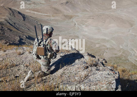 A U.S. Soldier of Bandit Troop 1st Tiger Squadron 3rd Cavalry Regiment provides overwatch security while soldiers move up Pride Rock mountain to witness the reenlistment of two U.S. Soldiers in Paktya province, Afghanistan. Stock Photo