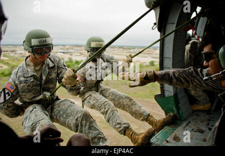 Sgt. Jon Garcia right, from Santa Cruz, Calif., and a repel master at the Fort Hood Air Assault School, gives a student the sign to execute the repel out of a UH-60 Black Hawk Helicopter from A Company 'Werewolves,' 3rd Assault Helicopter Battalion, 227th Aviation Regiment, 1st Air Cavalry Brigade, 1st Cavalry Division, during the Fort Hood Air Assault School's repel training here, Sept. 14. Pilots and crews of the Werewolves flew out in support of Fort Hood's Air Assault School in order to certify pilots and crews, and to also support the school's training of their students. Stock Photo