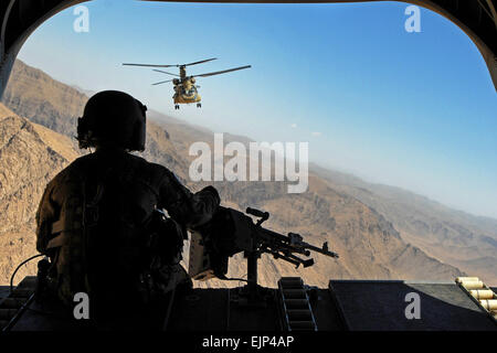 Sgt. Zach Smola, rear door gunner on a CH-47, keeps watch on the mountains in Uruzgan province, Afghanistan, May 12, 2013. The Chinooks, operated by members of Bravo Company, 2nd Battalion, 104th Aviation Regiment from the Connecticut and Pennsylvania Army National Guard, have played a vital part in the mission in Afghanistan since their arrival in December 2012 by performing resupply, retrograde, and planned missions.  Sgt. Jessi Ann McCormick Stock Photo