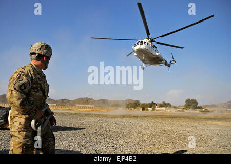 U.S. Army Spc. Pete Sigala, who hails from Anaheim, Calif., a helicopter landing zone sling load specialist from Headquarters Company, 626th Brigade Support Battalion, 3rd Brigade Combat Team “Rakkasans,” 101st Airborne Division Air Assault, awaits as a civilian contacted air asset helicopter approaches for a sling load of supplies at Forward Operating Base Salerno, Nov. 5, 2012. Sling loads help resupply soldiers at outlining Combat Outposts and FOBs with essential items such as fuel, water, food and other various supplies.  Sgt. 1st Class Abram Pinnington, TF 3/101 Public Affairs Stock Photo