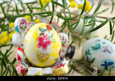 Hand painted decoupage Easter egg on wooden surface with a Happy Easter card and two toy rabbits Stock Photo