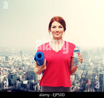 smiling girl with bottle of water after exercising Stock Photo