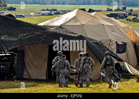 U.S. Army Soldiers litter transport a simulated injured patient to the Charlie medical tent during Joint Readiness Training Center, Fort Polk, La., Oct. 15, 2012. JRTC 13-01 is designed to prepare and educate U.S. military service members in a simulated combat environment. Stock Photo