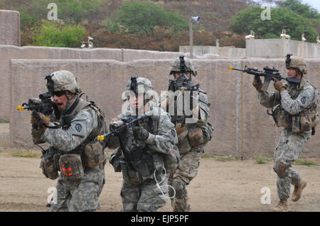 Soldiers from B Company, 1st Battalion, 27th Infantry Regiment, 2nd Brigade Combat Team, 25th Infantry Division, cross an open courtyard in search of a high-value target during a situational training exercise on June 25 at Marine Corps Training Area Bellows, Hawaii. The situational training exercise focused on tactics for a raid in an urban environment and marked the battalion's first platoon-level training of 2012. Stock Photo