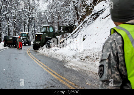 Soldiers of the West Virginia Army National Guard assigned to 821st Engineering Company from Summersville, W.Va., assist in debris and snow cleanup in Nicholas County.  The estimated two feet of snow caused havoc throughout the county, but especially on many of the windy mountainous roads, where existing erosion combined with heavy, wet snow to cause land slides and fallen trees. Stock Photo