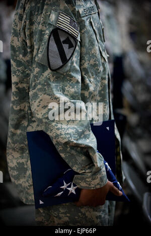 Philadelphia Eagles' Clifton Geathers holds a large American flag with a US  Air Force Airman to the left and a US Army Soldier to the right as the  National Anthem is played